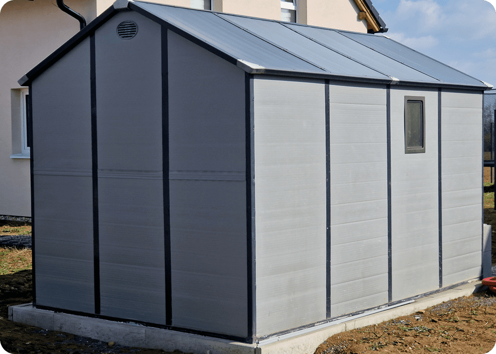 Grey shed in a fenced backyard.